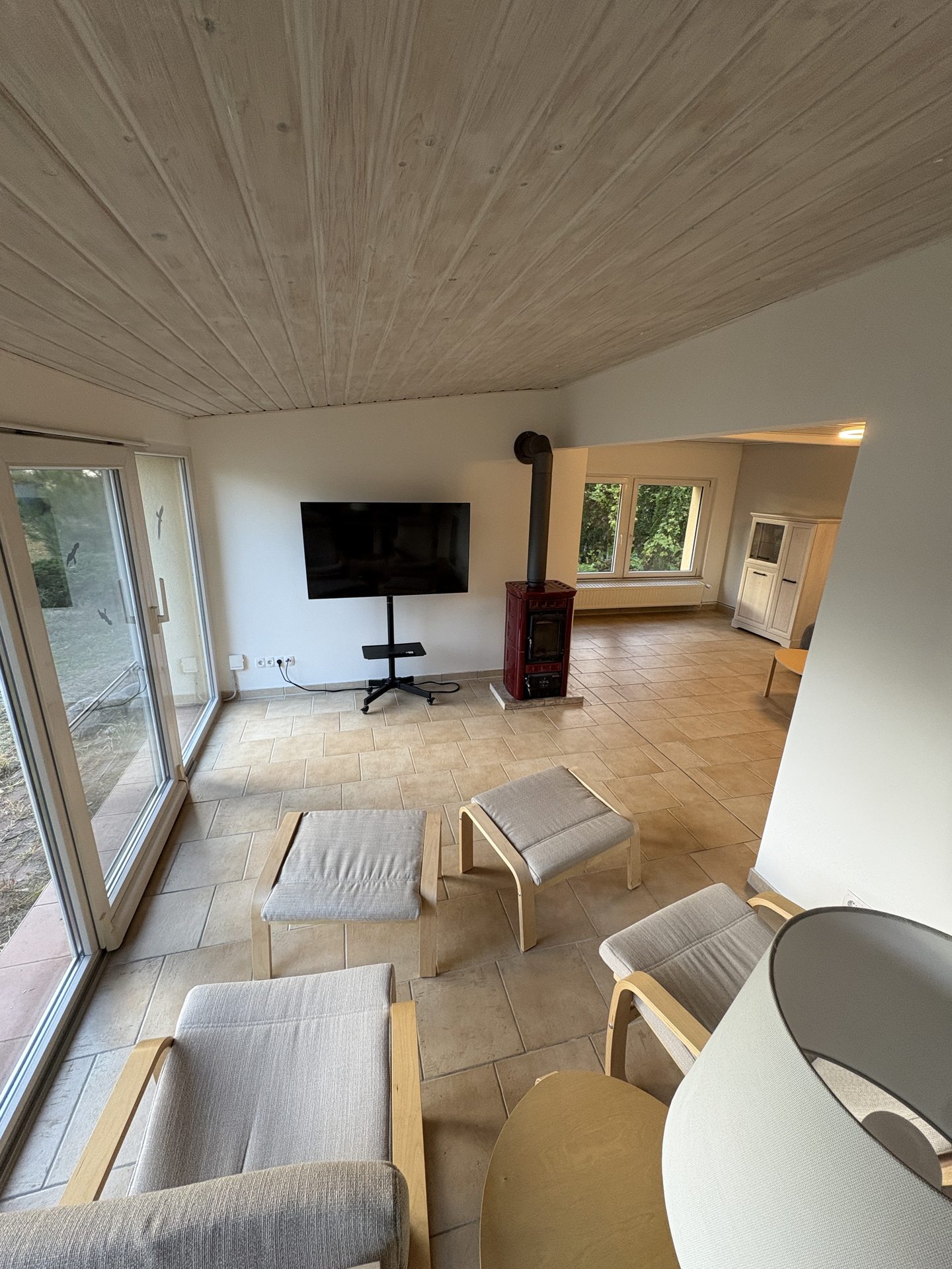 Wohnzimmer mit Fernseher und Fensterfront